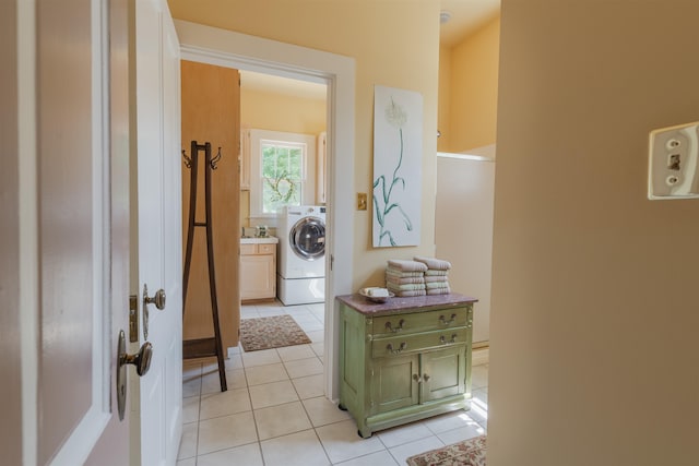 corridor with washer / clothes dryer and light tile patterned floors