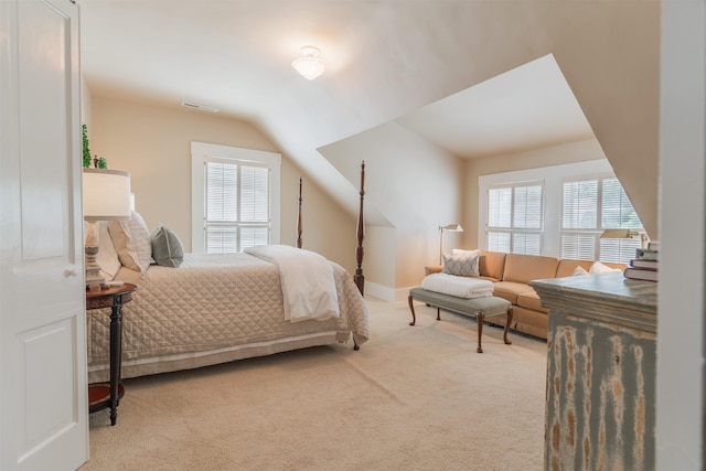 bedroom featuring light carpet, multiple windows, and lofted ceiling