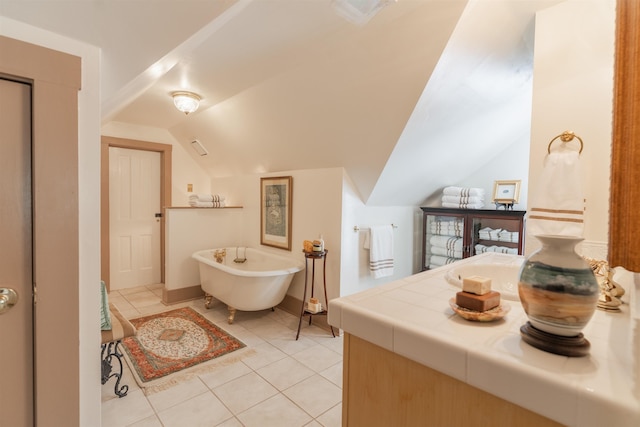 full bathroom with tile patterned floors, visible vents, lofted ceiling, and a freestanding bath