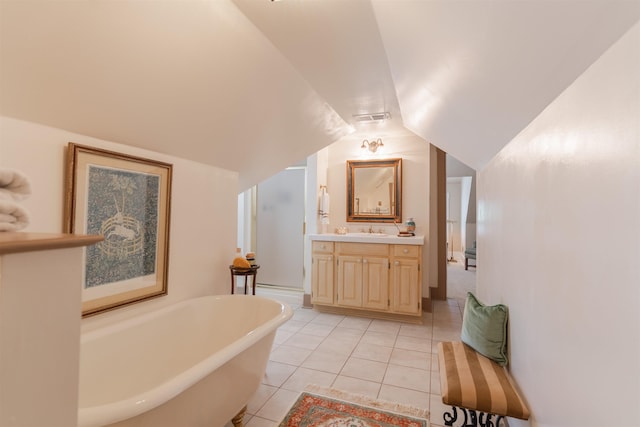 full bath with tile patterned floors, visible vents, a soaking tub, vanity, and vaulted ceiling