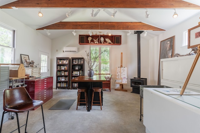 dining area with track lighting, a wood stove, lofted ceiling with beams, and a healthy amount of sunlight