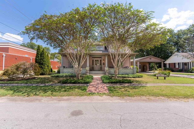 view of front facade featuring covered porch and a front lawn