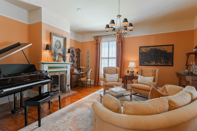 living room featuring wood finished floors, a notable chandelier, and a fireplace with raised hearth