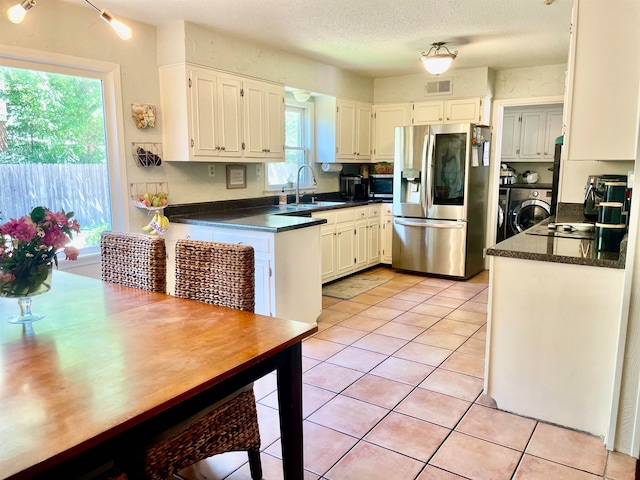 kitchen with white cabinets, a textured ceiling, sink, appliances with stainless steel finishes, and light tile patterned flooring