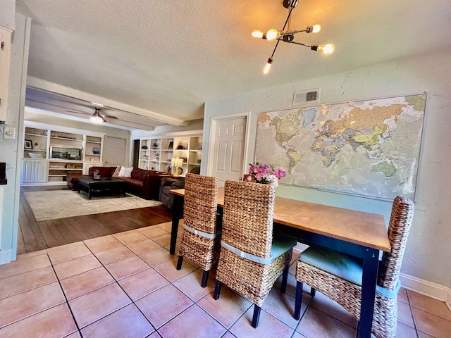 dining space featuring a textured ceiling, ceiling fan with notable chandelier, hardwood / wood-style floors, and built in features