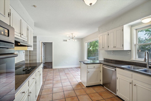 kitchen with a textured ceiling, stainless steel appliances, and white cabinetry