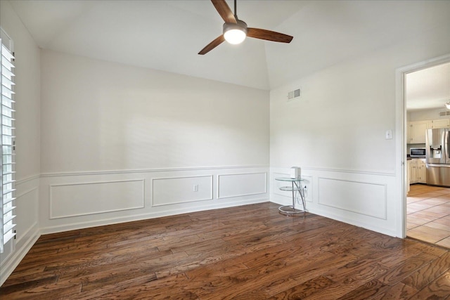 empty room featuring wood-type flooring, vaulted ceiling, and ceiling fan