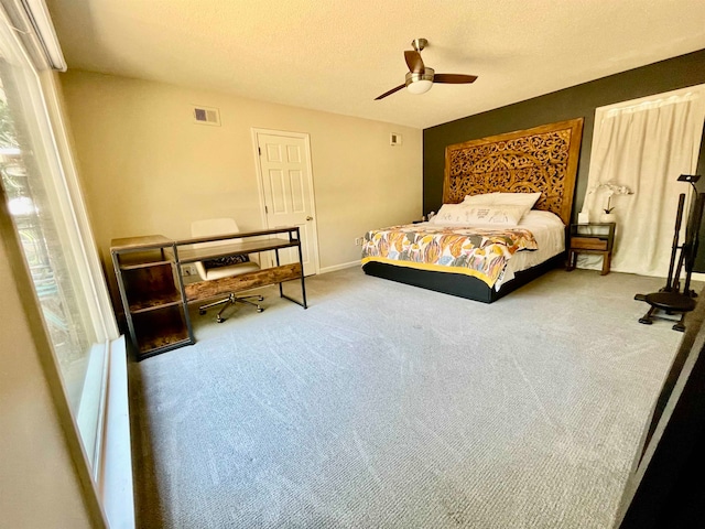 carpeted bedroom featuring a textured ceiling and ceiling fan