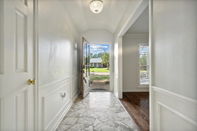 interior space featuring light wood-type flooring, lofted ceiling, and ornamental molding