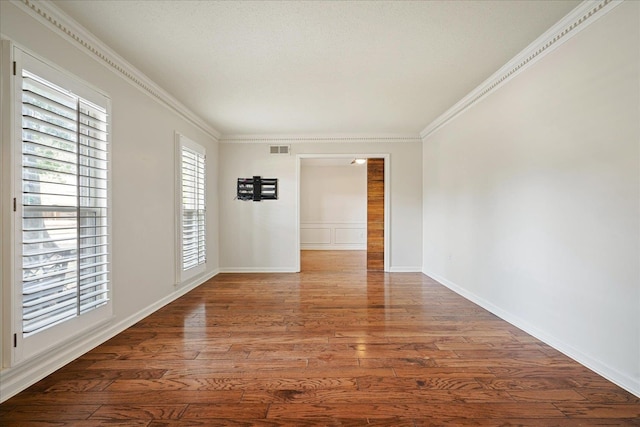 empty room with ornamental molding and dark hardwood / wood-style floors