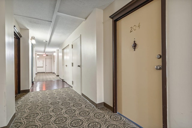 hall featuring a textured ceiling