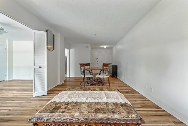 dining area featuring ceiling fan, a textured ceiling, and light hardwood / wood-style flooring