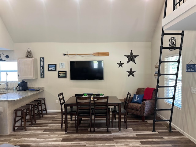 dining space featuring lofted ceiling, dark hardwood / wood-style floors, and sink