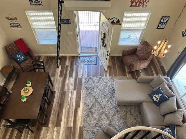 living room with a wealth of natural light, hardwood / wood-style floors, and a chandelier