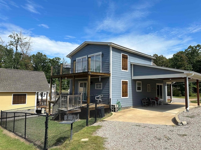 back of house with a balcony, a lawn, a patio area, and a deck