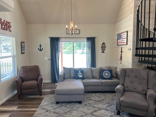 living room with dark hardwood / wood-style floors, high vaulted ceiling, and an inviting chandelier