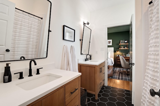 ensuite bathroom with ensuite bathroom, two vanities, and a sink