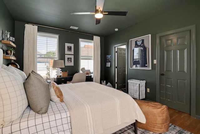 bedroom featuring ceiling fan, visible vents, and wood finished floors