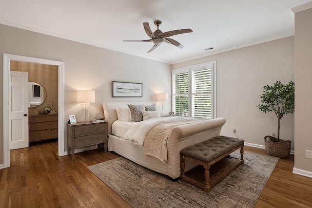 bedroom with ornamental molding, visible vents, baseboards, and wood finished floors