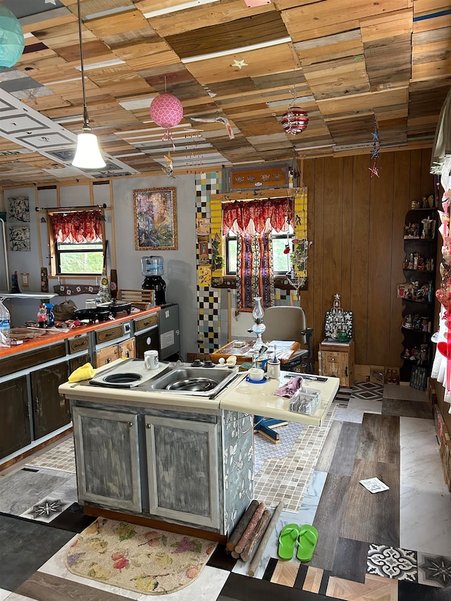 kitchen with wood walls, hardwood / wood-style floors, wooden ceiling, and decorative light fixtures