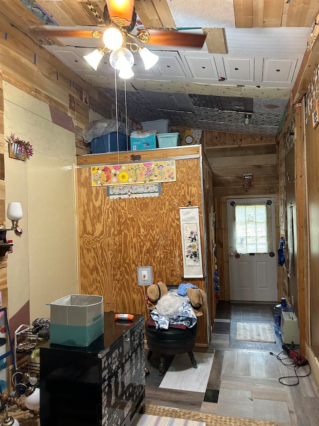 interior space featuring wood walls, ceiling fan, and hardwood / wood-style flooring