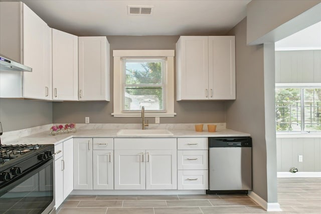 kitchen with stainless steel dishwasher, black range with gas cooktop, sink, and white cabinets