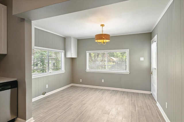 unfurnished dining area with light wood-type flooring, plenty of natural light, and crown molding