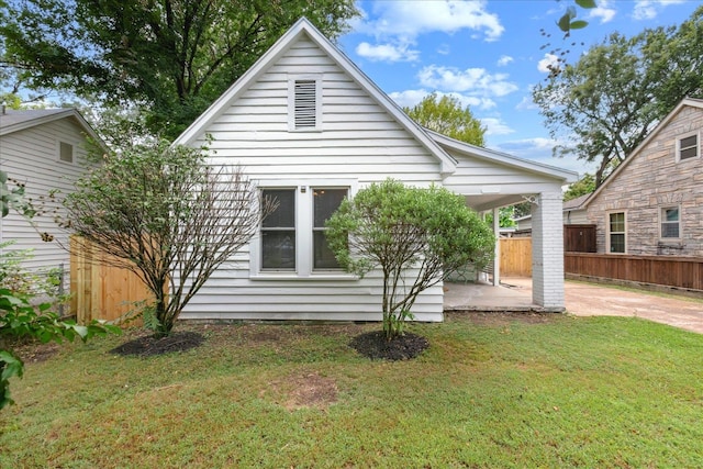 rear view of property featuring a patio area and a yard