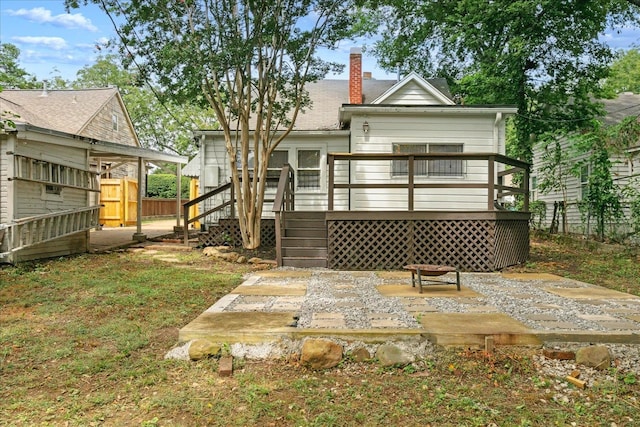 rear view of property with a wooden deck and a patio