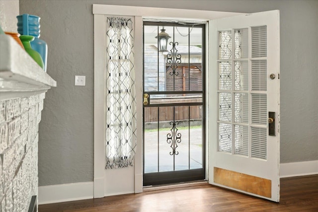 doorway to outside with wood-type flooring and a chandelier