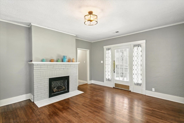 unfurnished living room with dark wood-type flooring, ornamental molding, and a brick fireplace