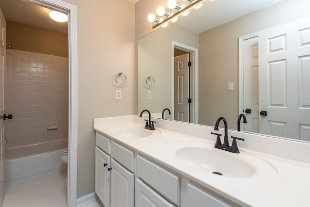 bathroom featuring tile patterned flooring, double vanity, toilet, and a sink