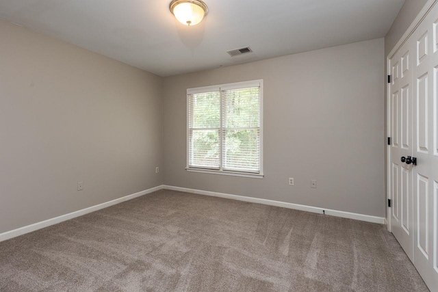 carpeted empty room with baseboards and visible vents