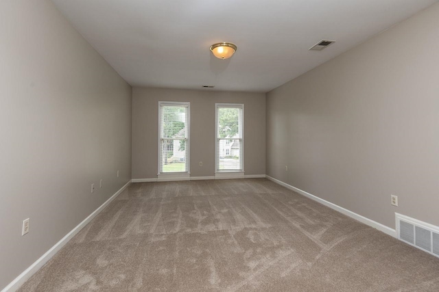 unfurnished room with visible vents, baseboards, and carpet