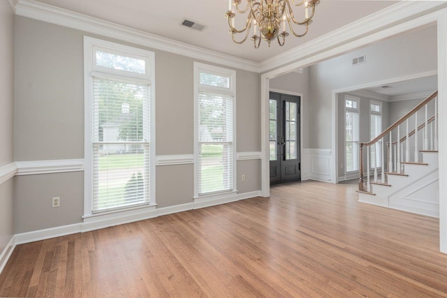 interior space with stairs, wood finished floors, visible vents, and ornamental molding