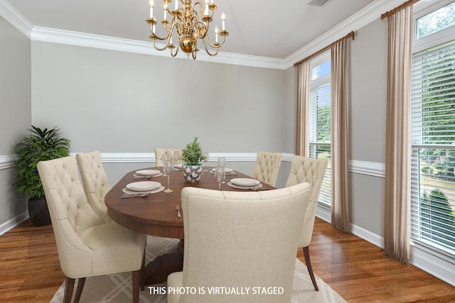 dining room with wood finished floors, baseboards, and ornamental molding