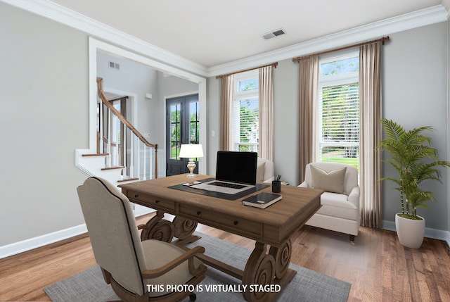 office featuring baseboards, wood finished floors, visible vents, and ornamental molding