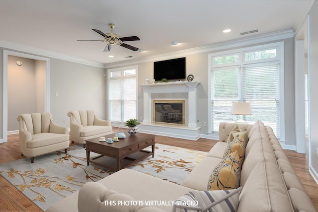 living room featuring visible vents, crown molding, baseboards, and wood finished floors