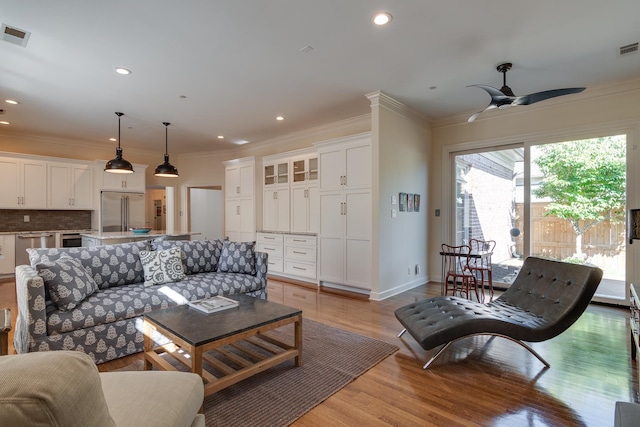 living room featuring ceiling fan, light hardwood / wood-style floors, and ornamental molding