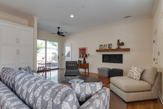 living room with ornamental molding, hardwood / wood-style flooring, and ceiling fan