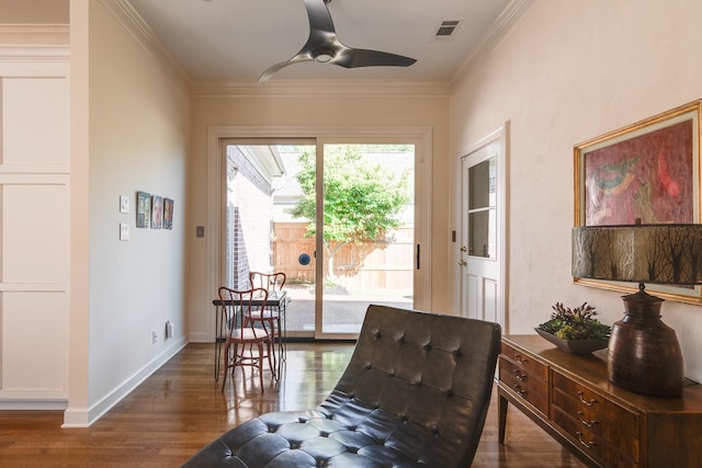 sitting room with crown molding, dark wood-type flooring, and ceiling fan