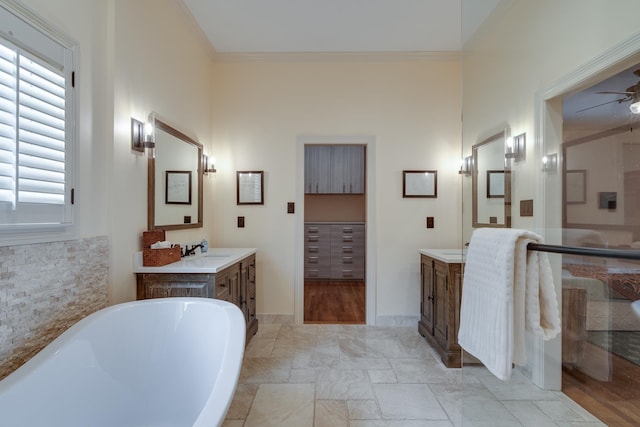 bathroom featuring vanity, wood-type flooring, ornamental molding, a bathtub, and ceiling fan