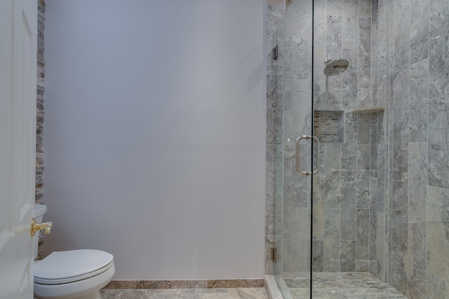 bathroom with tile patterned flooring, toilet, and a shower with door