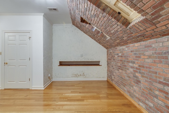 unfurnished living room with lofted ceiling, crown molding, and light wood-type flooring