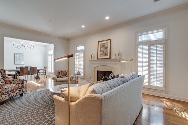 living room featuring crown molding, wood-type flooring, and a chandelier