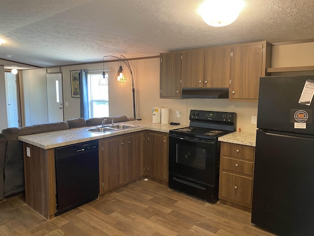 7080 Beauty Hill Rd, Adamsville, TN 38310 - kitchen with dark wood-type flooring, a textured ceiling, black appliances, under cabinet range hood, and a sink