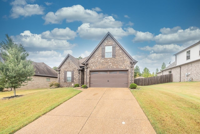 tudor home with a front yard and a garage