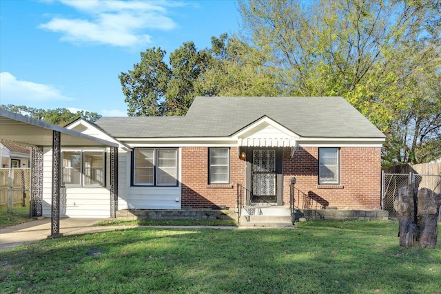 bungalow with brick siding, a front yard, and fence