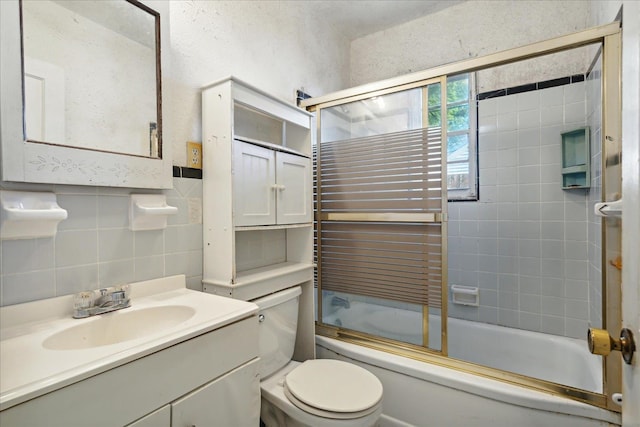 full bathroom featuring toilet, tasteful backsplash, tile walls, vanity, and enclosed tub / shower combo