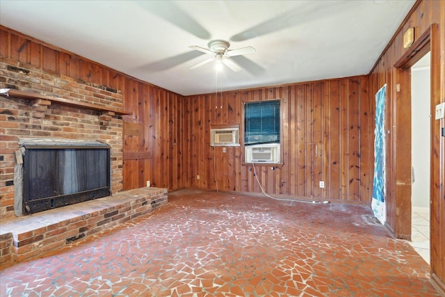 unfurnished living room featuring cooling unit, ceiling fan, a brick fireplace, and wood walls